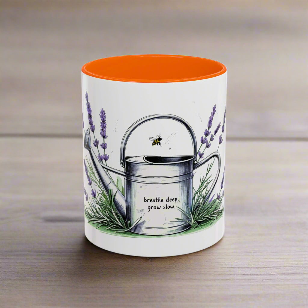 Mug with orange interior, lavender design, and text 'breathe deep, grow slow' on a white background